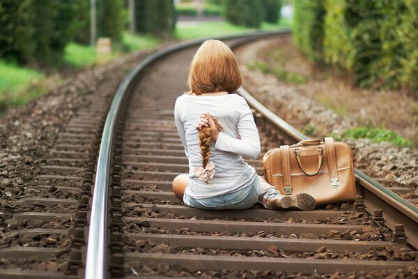 La jeune fille a coupé les cheveux de Paul carré et s est assise sur les rails