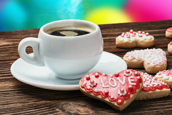 A cup of coffee and cookies in the form of hearts