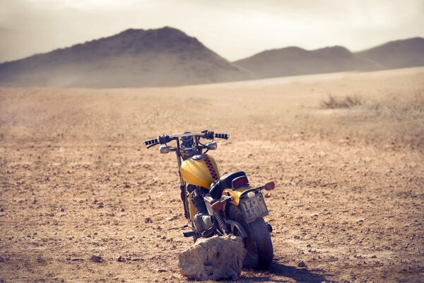 Una vieja moto en un campo en medio de colinas