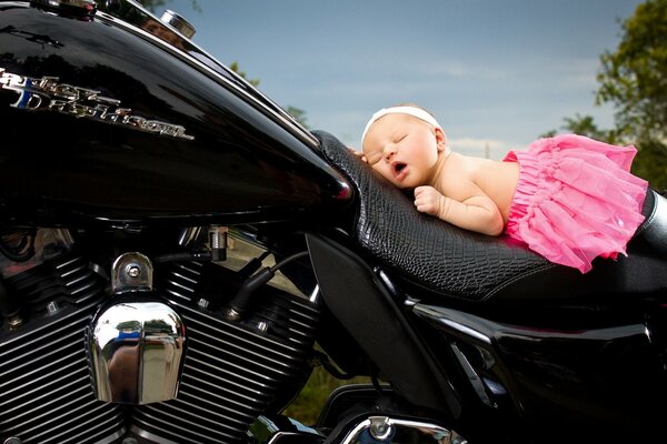 Sleeping girl on a beautiful black motorcycle