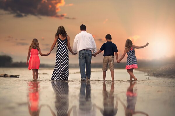 Reflection in the water of a family with children