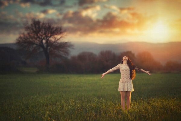 The girl basks in the rays of the departing sun