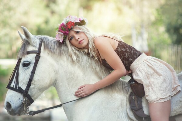 Nelly lehtinen with a wreath on her head riding a white horse