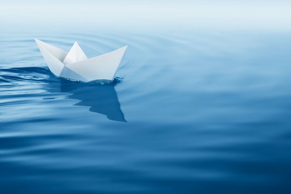 A brave paper boat sailing on blue waves