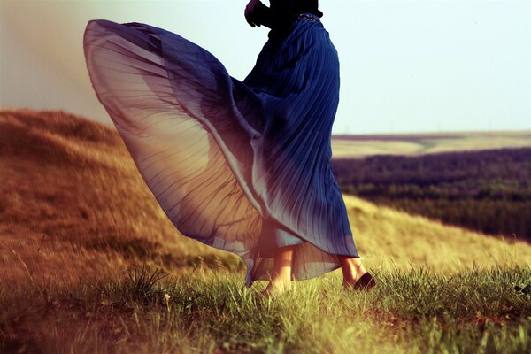 A girl running across the field in a dress