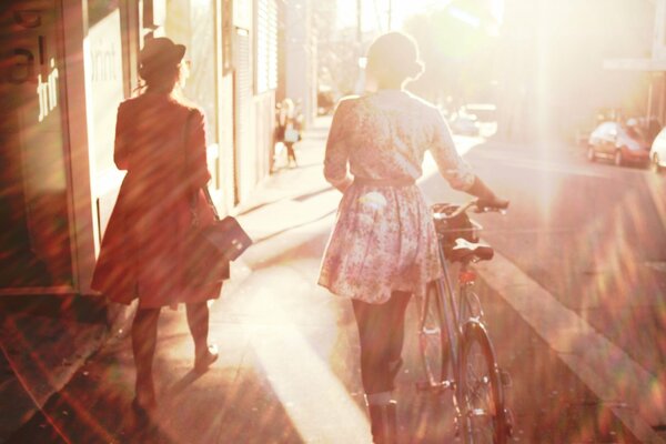 Chica con bicicleta en la calle soleada