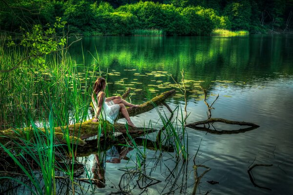 De la forêt, lac. La jeune fille se baigne les pieds