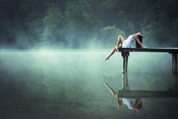 Reflection of the girls in the morning in the lake