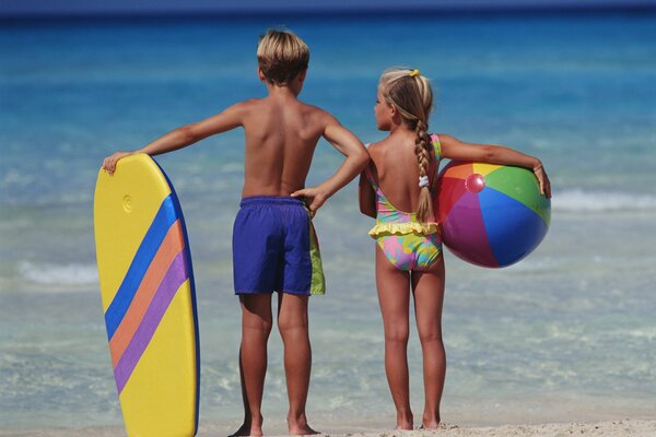 Niña y niño mirando a la distancia del mar