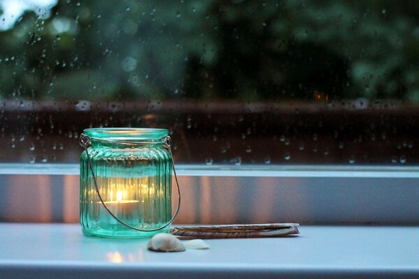 Leuchten auf der Fensterbank eine Kerze in einem Glas