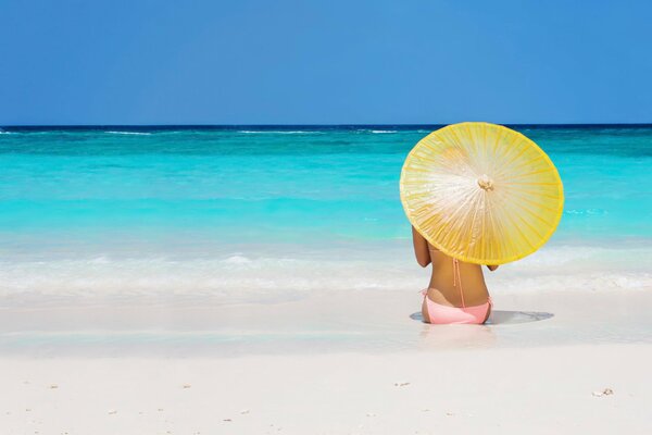 Sur la mer avec un parapluie fille sur la plage