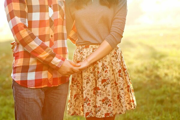 A man and a woman in love hugging a couple without a face on the background of meadow grass