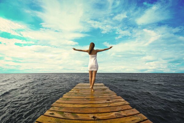 Girl on in a dress, between the sky and the ocean