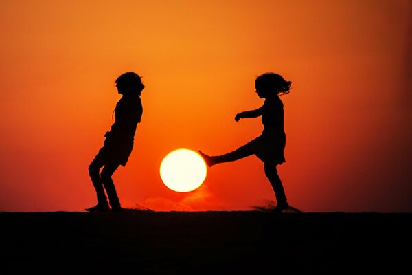 Silhouettes des enfants au coucher du soleil