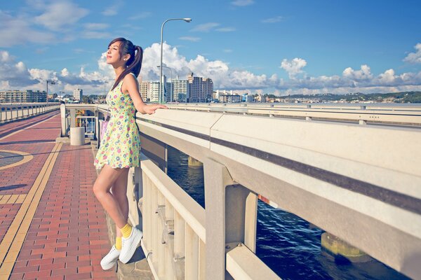 Chica en un vestido en el paseo marítimo