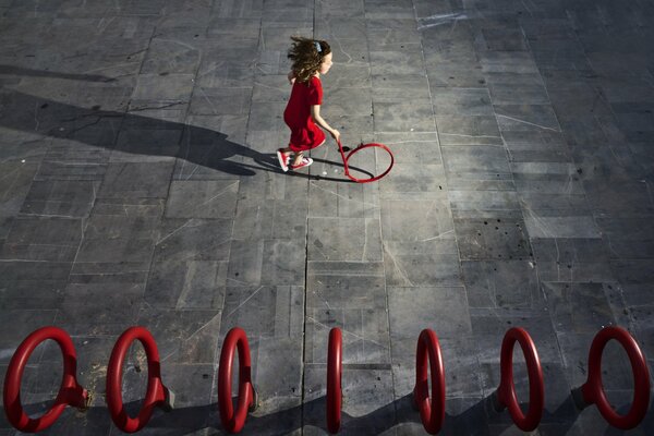 Chica con vestido rojo corriendo alrededor