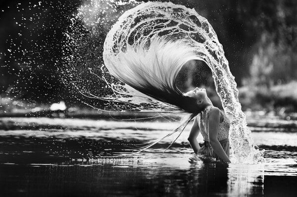 Mädchen inszeniert Spritzen auf dem Wasser mit nassen Haaren