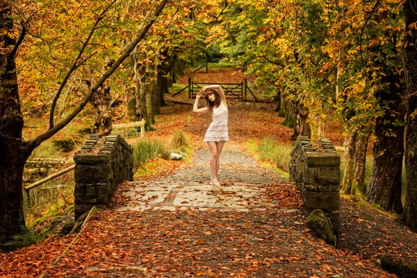 Herbstpark mit einem verträumten Mädchen