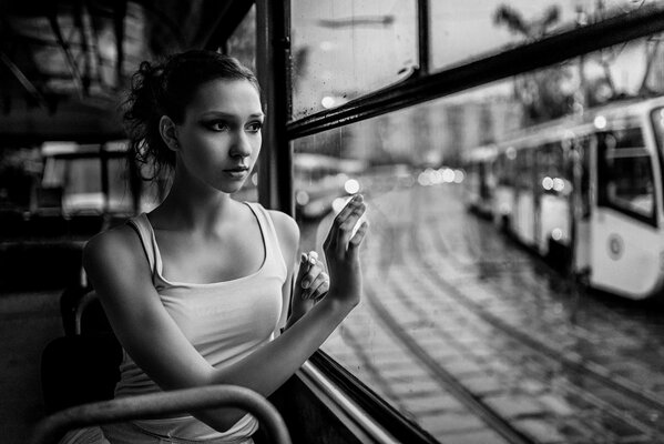 A ballerina rides a tram and looks out the window at an oncoming tram