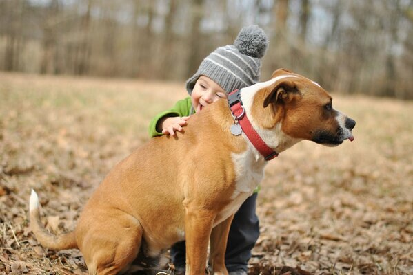 Ragazzo con un sorriso che abbraccia il cane