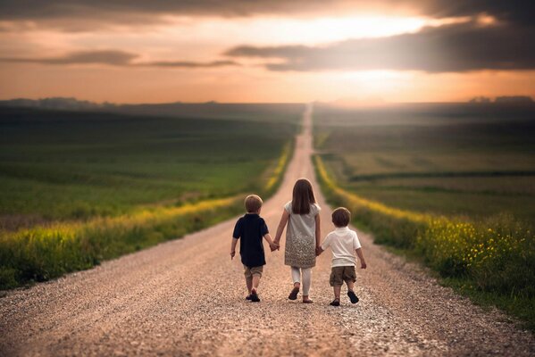 Los niños caminan por el camino hacia el campo