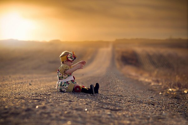 An elegant girl is sitting by the road