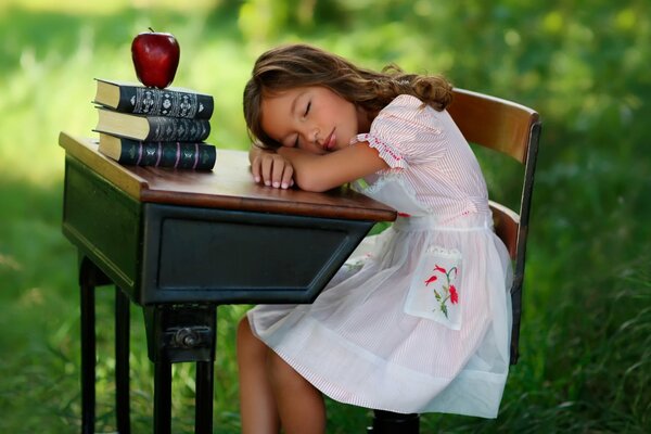 The girl is sleeping at her desk