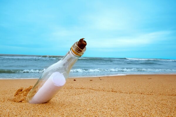 Der Brief ist eine Botschaft in einer Flasche im Sand des Meeres. Strand auf Vollbild-Hintergrund