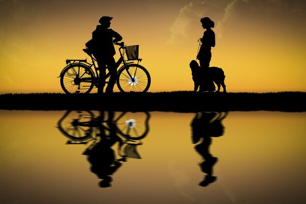 Un tipo en bicicleta. Silueta de una niña con un perro