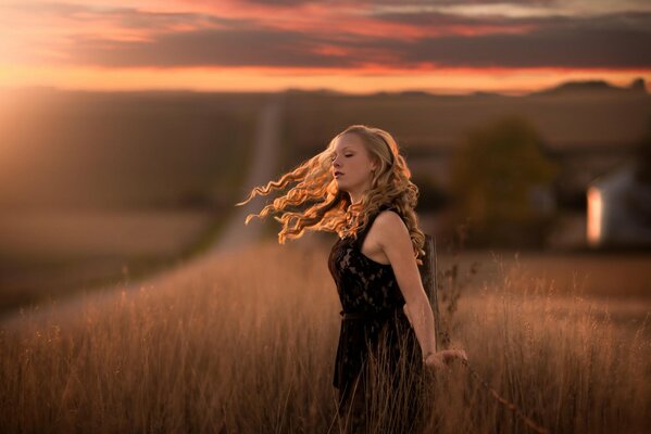 Mädchen im Gras mit Wind im Haar