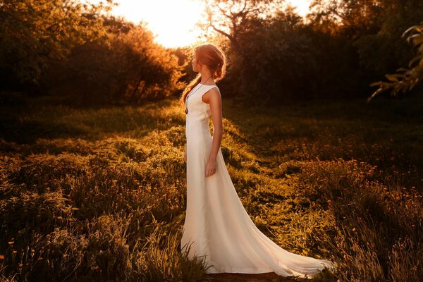 Mädchen im weißen Kleid bei Sonnenuntergang