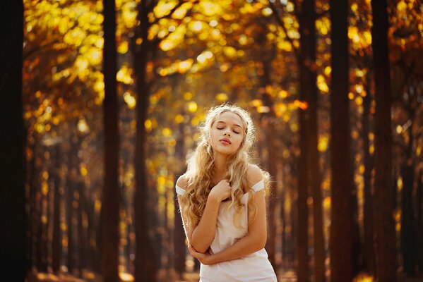 Chica en el fondo del bosque de otoño