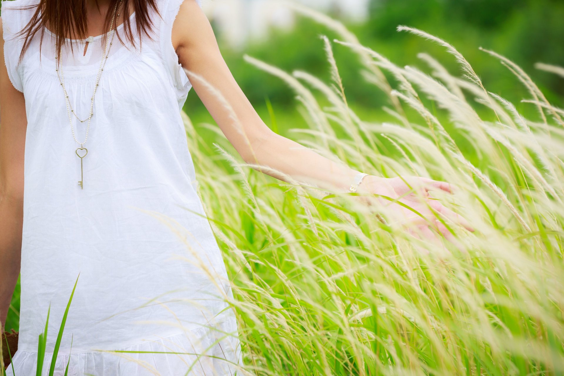 mood girl pendant key key heart heart hand grass greenery background. widescreen full-screen wallpaper