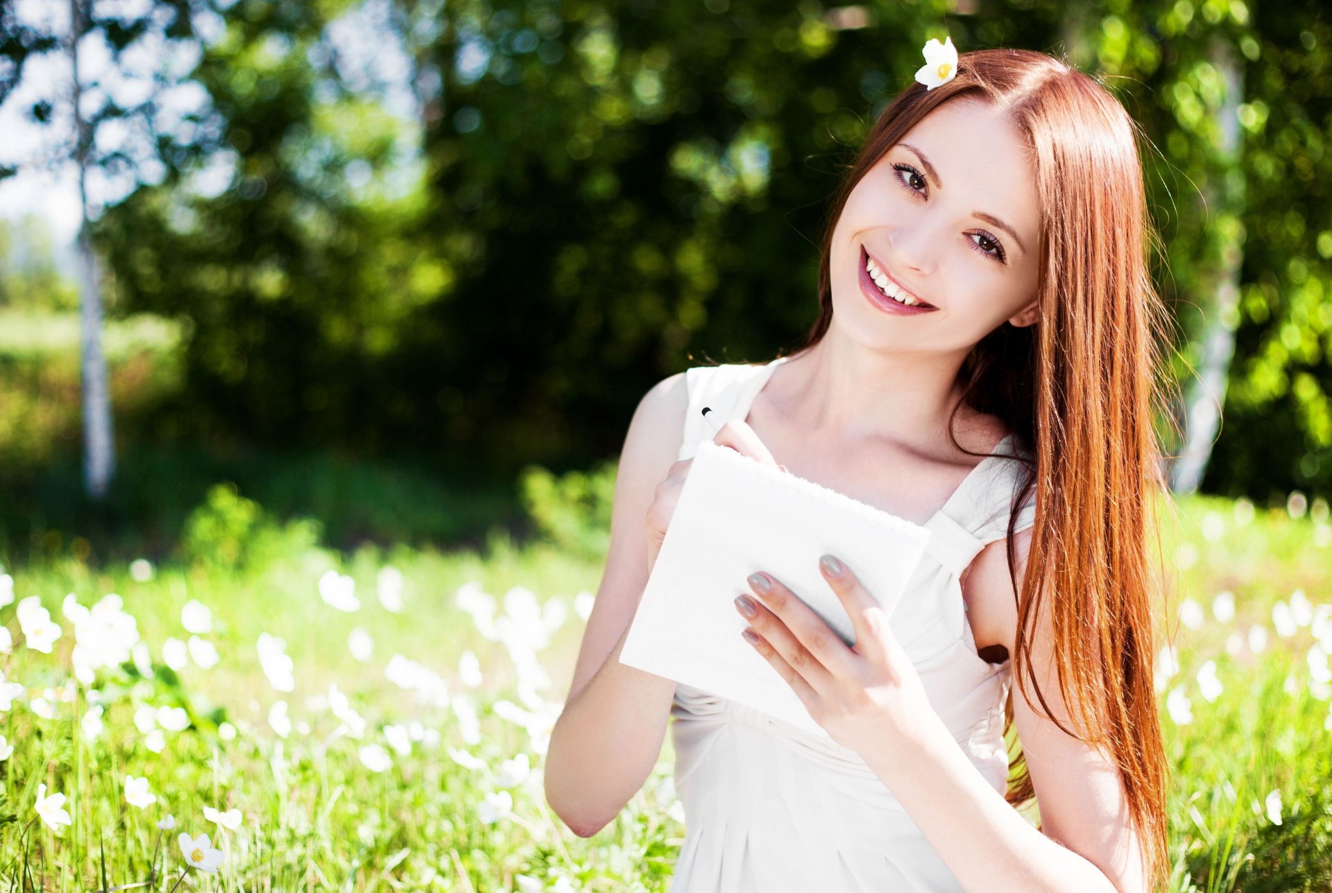 estados de ánimo chica pelirroja sonrisa mirada manos. papel bloc de notas hoja naturaleza campo flores flores sol desenfoque fondo papel pintado pantalla ancha pantalla completa pantalla ancha pantalla ancha