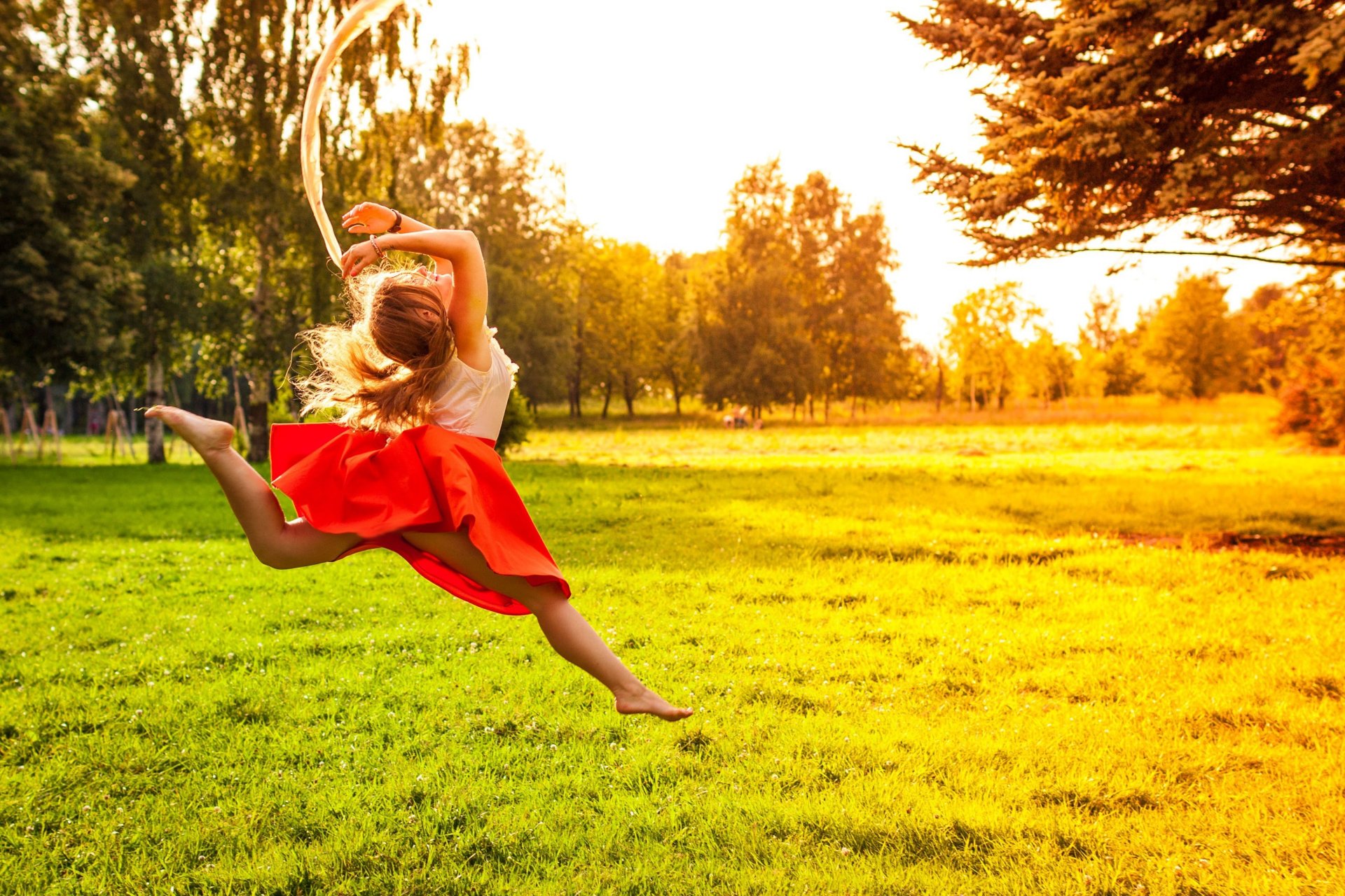 umore ragazza salto gioia felicità positivo gambe gonna natura erba verde sole alberi albero foglie fogliame. foglietti sfondo carta da parati widescreen schermo intero widescreen widescreen