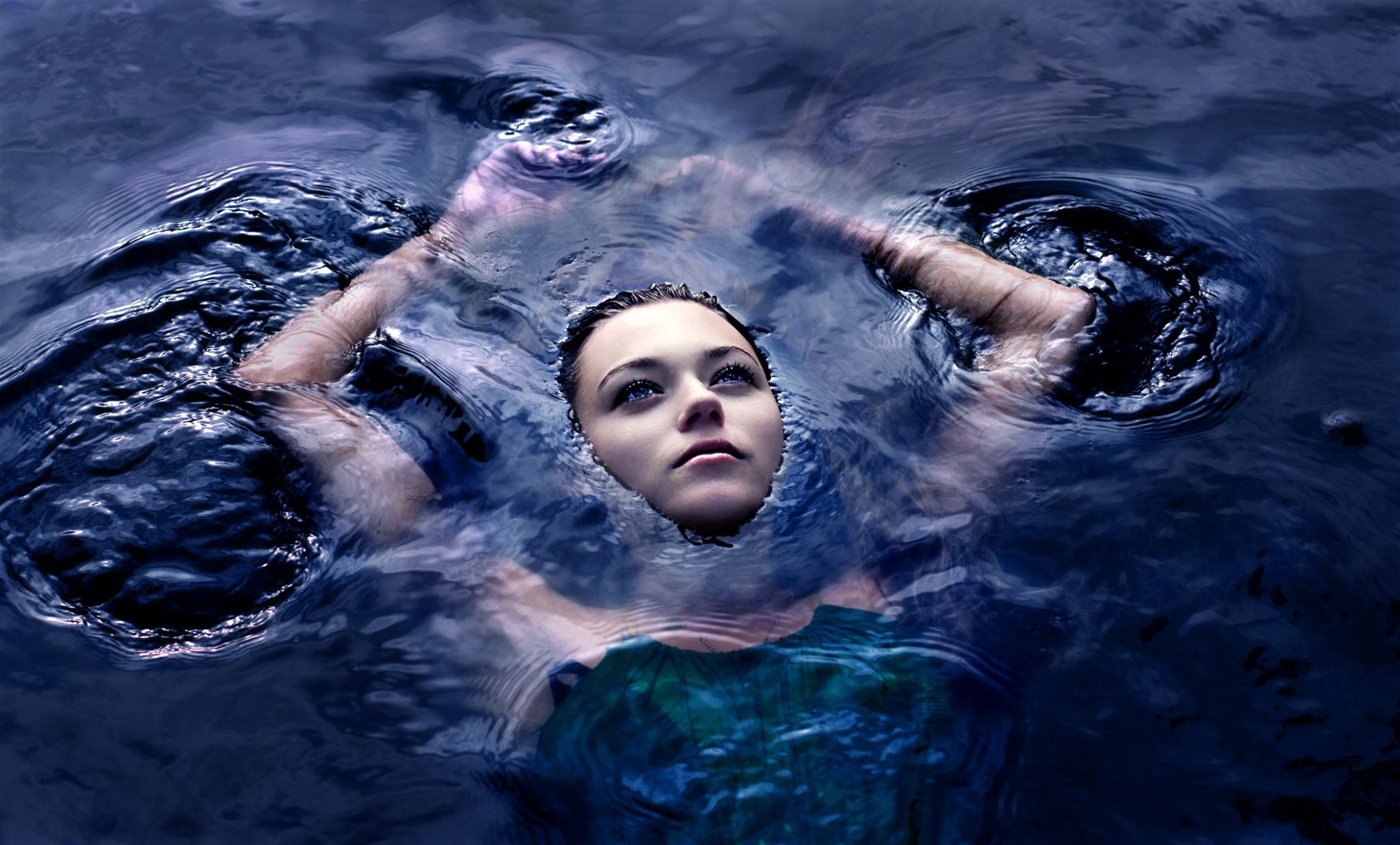 chica pelo oscuro agua superficie manos cara mirada abismo