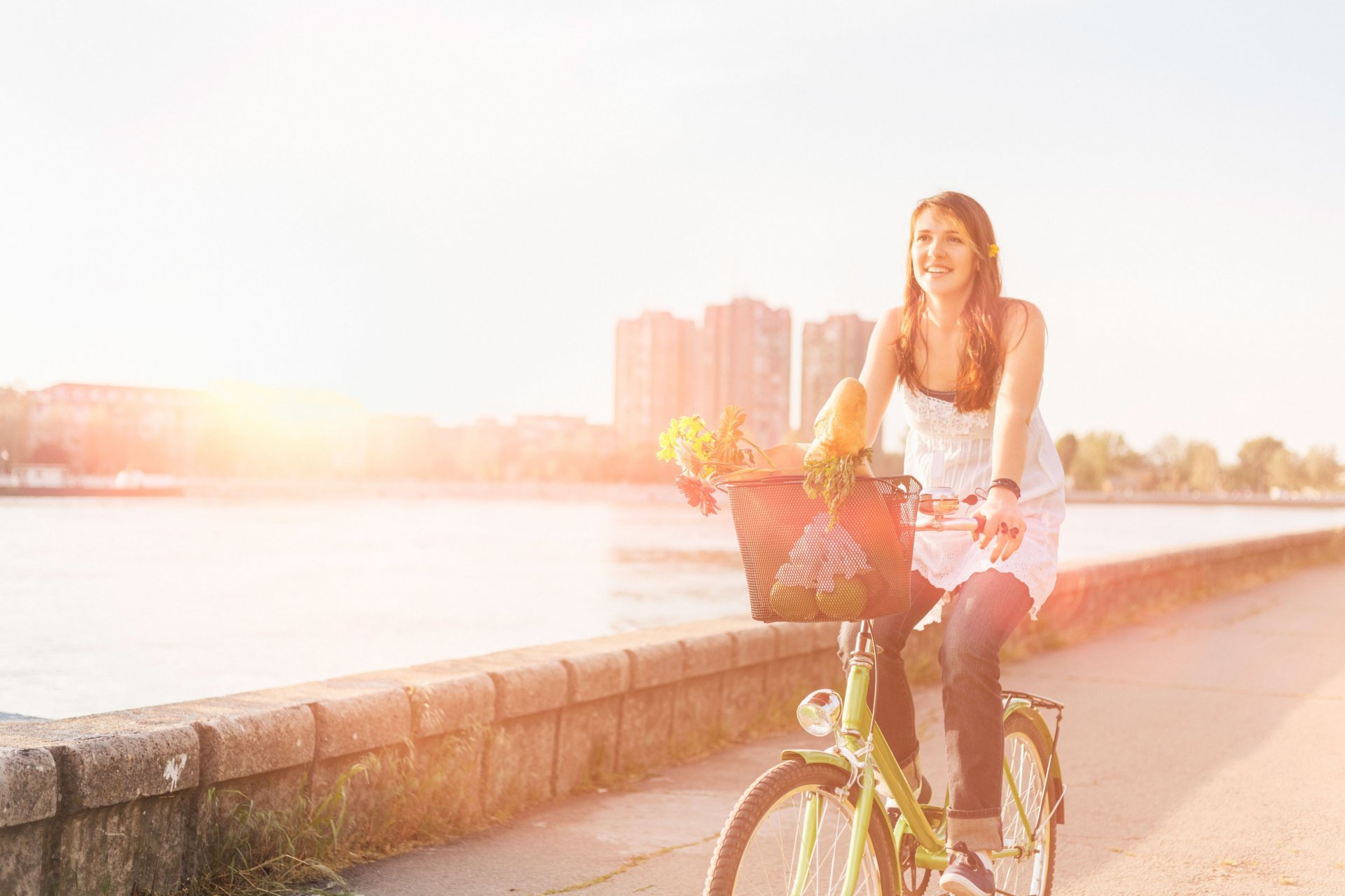 humeur fille sourire joie sport vélo panier panier fleurs fleurs route rue asphalte eau rivière bâtiment soleil fond fond d écran écran large plein écran écran large écran large