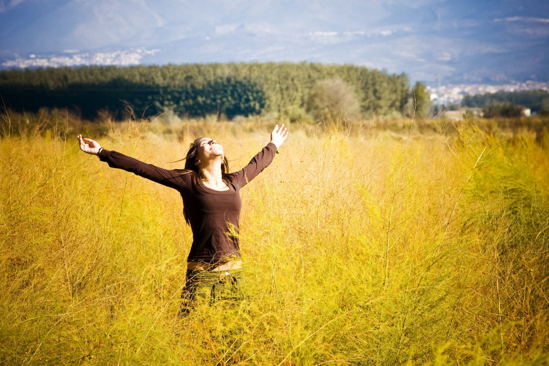 umore ragazza donna bruna positivo gioia felicità libertà mani sorriso pianta fiori alberi albero foglie volantini sfondo widescreen schermo intero widescreen carta da parati