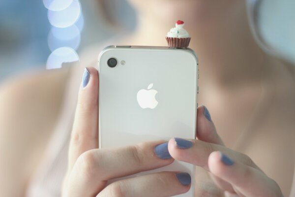 Petit gâteau sur le téléphone dans les mains