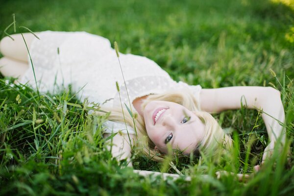 Smiling blonde girl on the grass