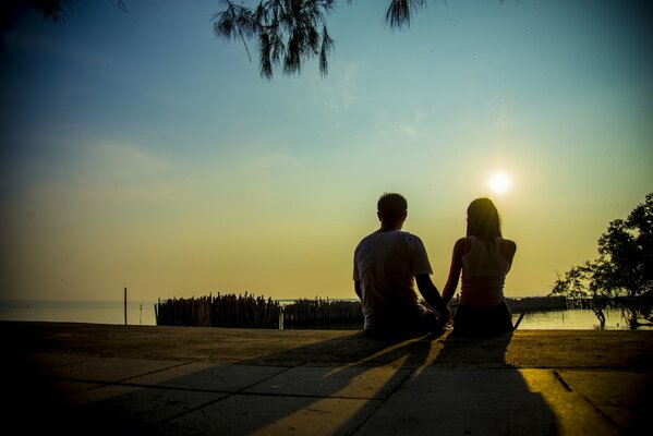 A couple of lovers on the background of a sunset on the lake shore