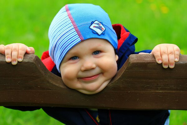 Garçon souriant sur un banc de parc