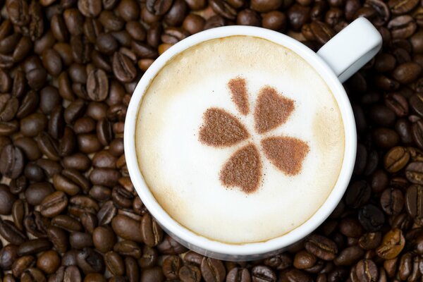 Caffè con schiuma e motivo a trifoglio