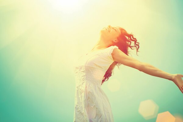 The girl rejoices in the sun by opening her soul