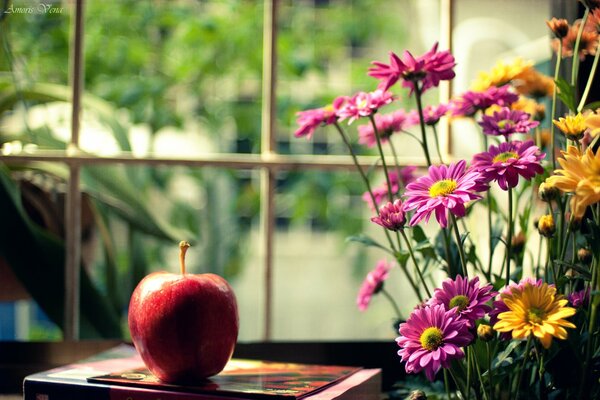 Mela rossa appetitosa con un mazzo di fiori