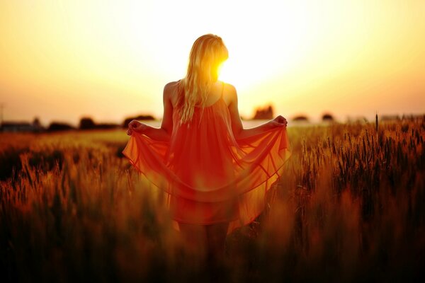 Chica en vestido rojo al atardecer en el campo