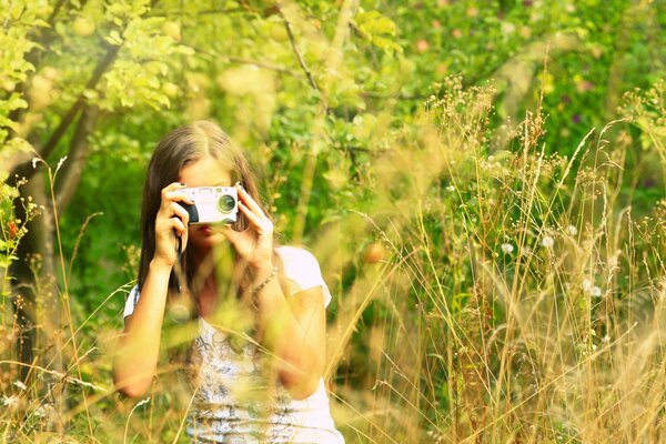 Girl in the field with a camera