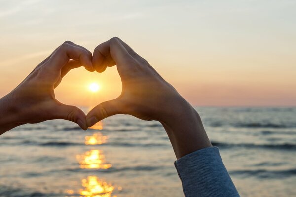 El sol en el corazón de las manos sobre el mar