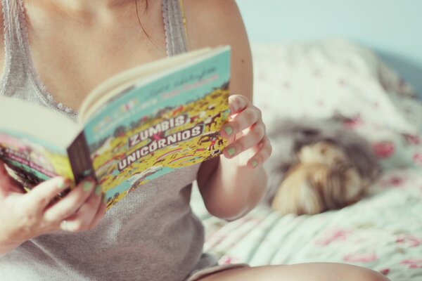 A girl on the bed with a book in her hands