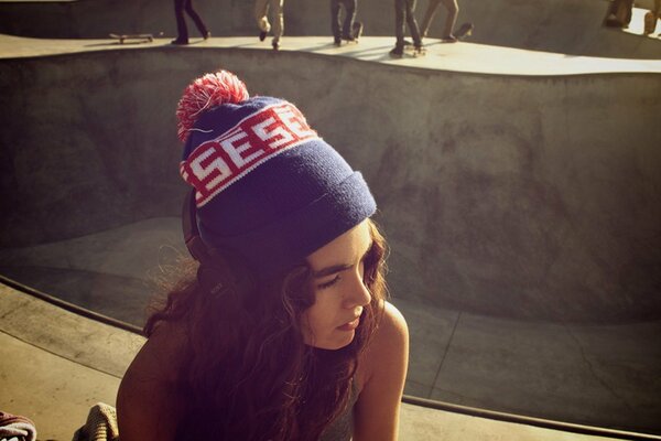 Curly-haired girl in a sunny skate park